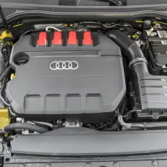 Silnik 2.0 TFSI z czerwonymi elementami i logo Audi. Widoczny akumulator i zbiornik płynu.