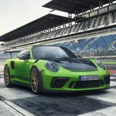 Zielony Porsche GT3 RS na torze wyścigowym. Sprawdź porsche gt3 rs cena i poczuj moc!