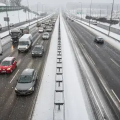 Autostrada A1 w zimowych warunkach, z samochodami i ciężarówkami na ośnieżonej nawierzchni.