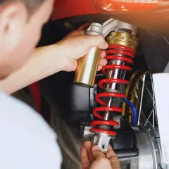 Mechanik wymienia amortyzator w skuterze. Sprawdź wymiana amortyzatorów cena, by zadbać o komfort jazdy.