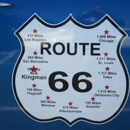 Tablica z napisem ROUTE 66 i odległościami do miast, w tym Kingman, gdzie jesteś.