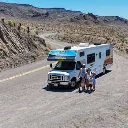 Rodzina na tle pustynnego krajobrazu i kamienistej drogi, idealne miejsce na przygodę w stylu road 66.