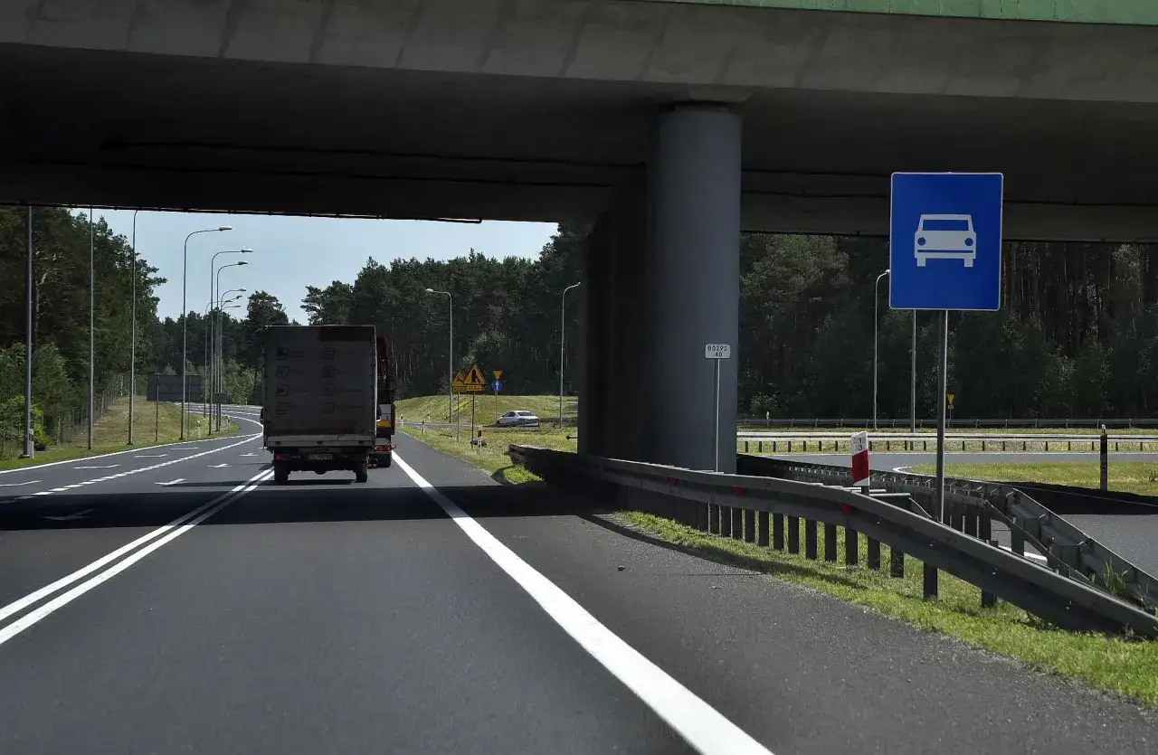 Droga ekspresowa jednojezdniowa z ruchem pojazdów pod wiaduktem.