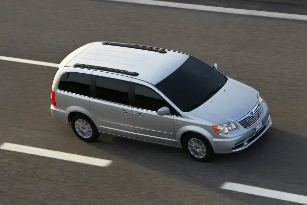 Srebrny Lancia Voyager jedzie po autostradzie.