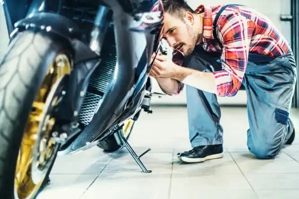 Mechanik sprawdza motocykl. Zastanawiasz się, ile kosztuje przegląd motocykla?