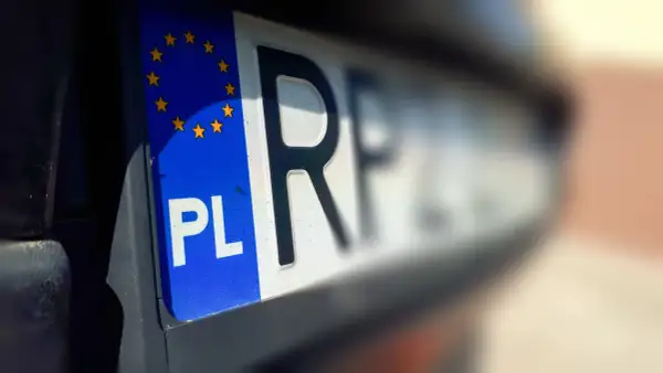 Zbliżenie na polską tablicę rejestracyjną z symbolem UE. Szybkie wyrejestrowanie auta online jest teraz możliwe.