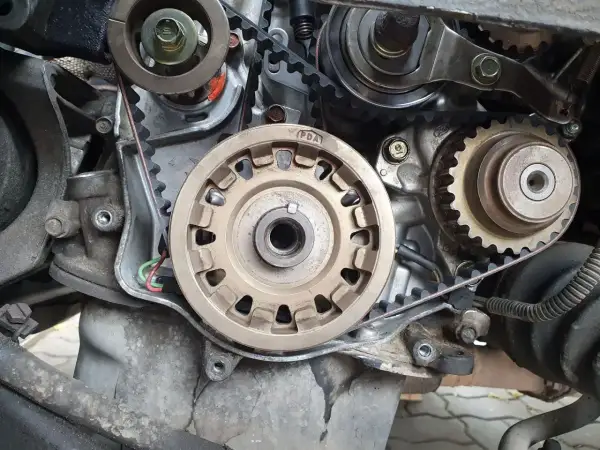 Widok na mechanizm napędu rozrządu silnika. Widać koła zębate, napinacz i pasek. Czas na wymianę rozrządu!
