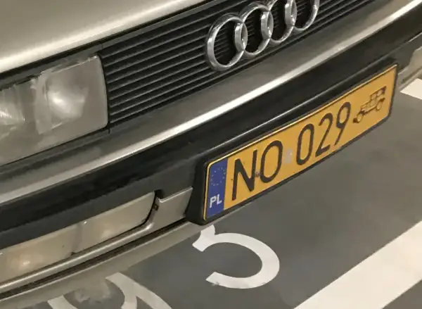 Przód Audi z charakterystycznym grillem i czterema pierścieniami. Widoczne żółte tablice rejestracyjne z numerem NO 029.