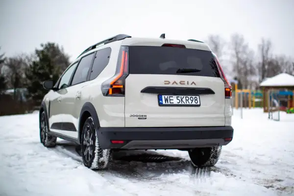 Biała Dacia Jogger Hybrid na śniegu. Sprawdź atrakcyjną dacia jogger cena i wybierz swój wymarzony samochód.